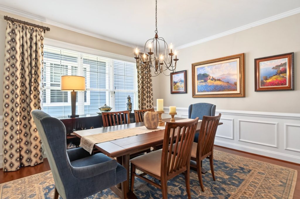 Dining room table and chairs beneath a wrought-iron chandelier