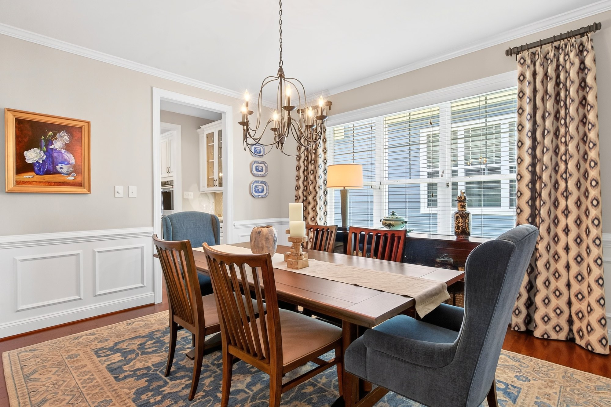 Dining room with floor-length patterned drapery and plantation shutters