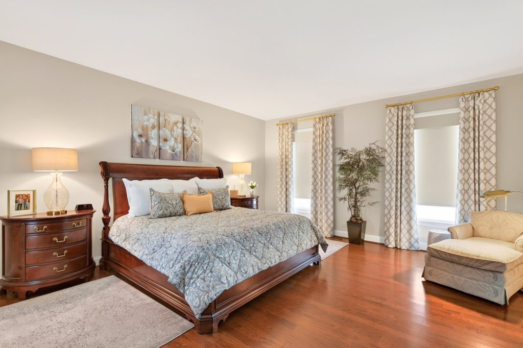 Primary suite, sleigh bed with patterned drapery at the windows