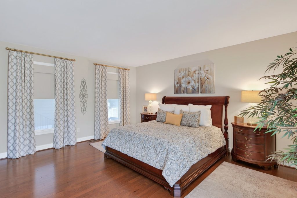 Primary suite with dual roller shades and stationary side panels