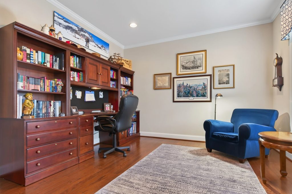 Study with built-in bookcases and a blue wing chair
