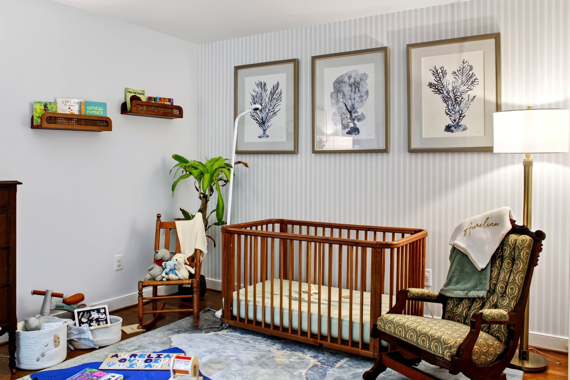 Nursery with a wooden crib, a rocking chair and botanical prints